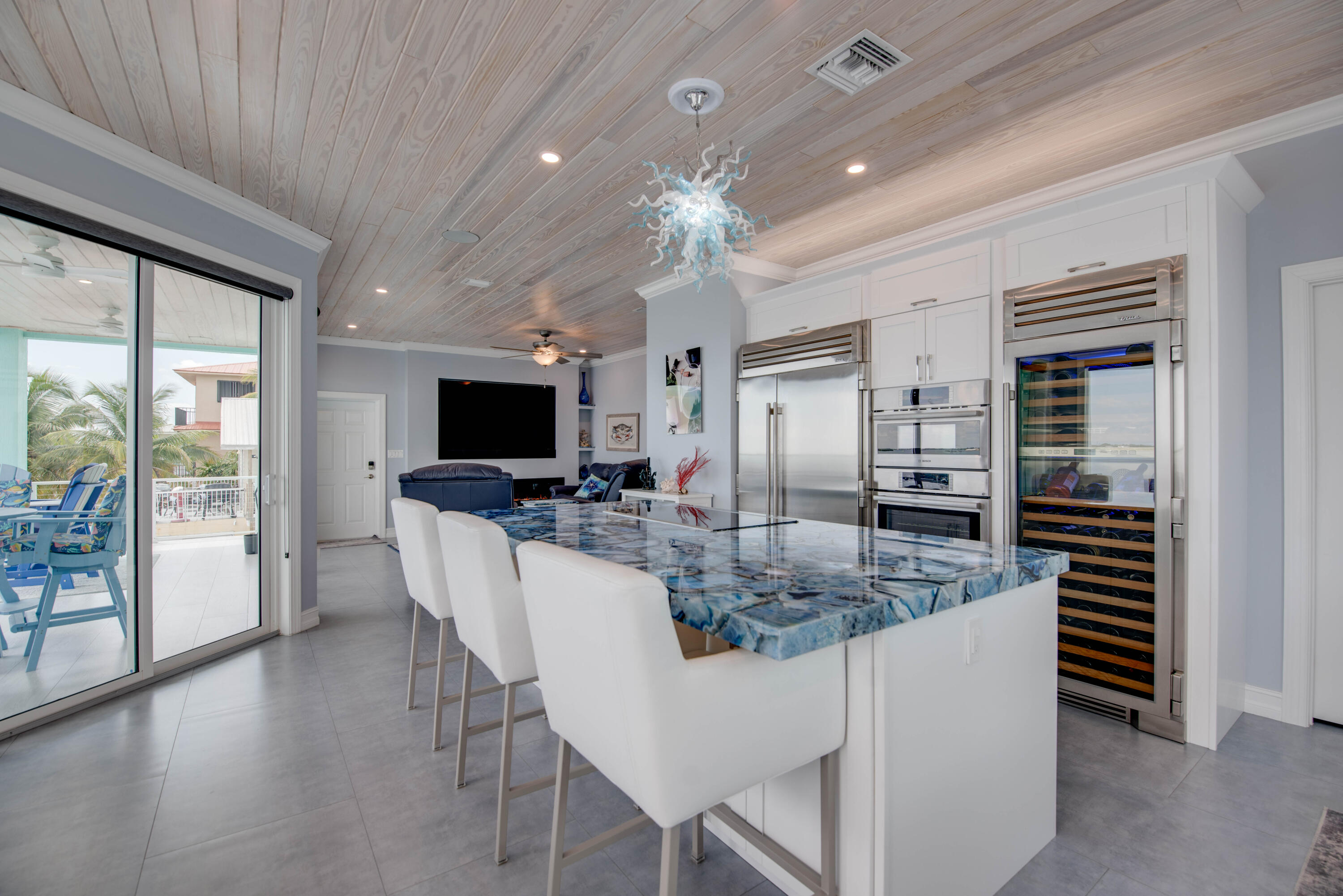747 La Fitte Road Summerland Key, FL 33042 - Photo 74 of 103 a kitchen with stainless steel appliances kitchen island granite countertop a stove top oven a sink a dining table and chairs with wooden floor