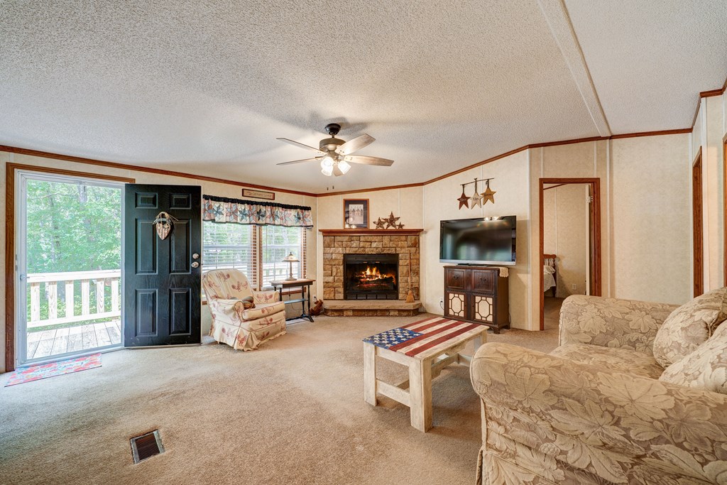 150 Hickory Hls Road Ellijay, GA 30540 - Photo 3 of 24 a living room with furniture a flat screen tv and a fireplace