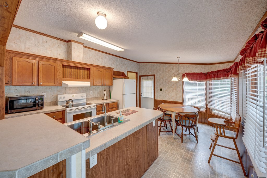 150 Hickory Hls Road Ellijay, GA 30540 - Photo 6 of 24 a kitchen that has a table chairs in it and wooden cabinets