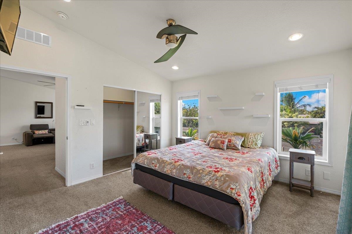 943 Kokomo Road Haiku, HI 96708 - Photo 15 of 50 a bedroom with a bed and a chandelier