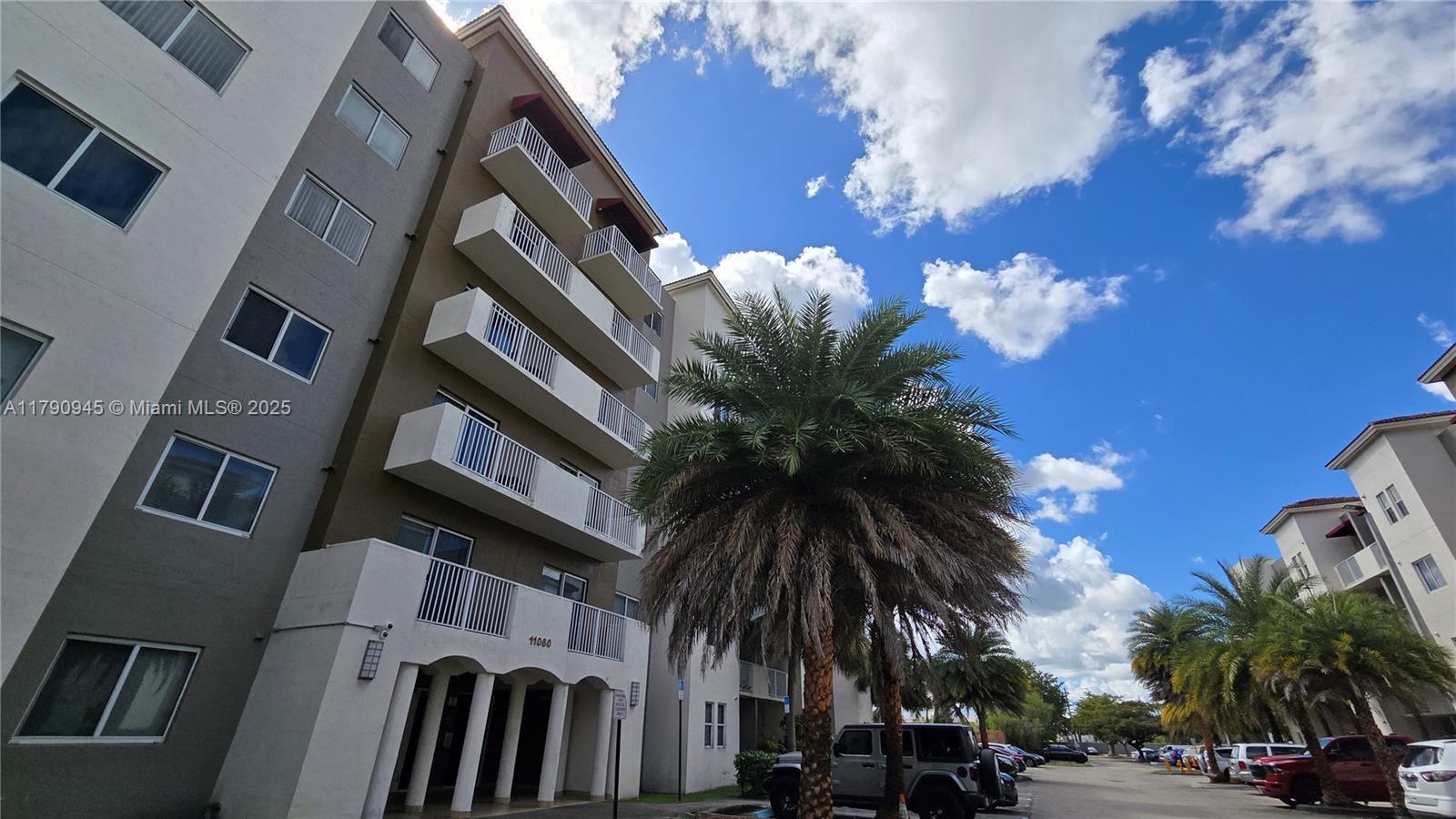 11060 Southwest 196th Street, Unit 407 Cutler Bay, FL 33157 - Photo 23 of 25 a view of multiple house with a yard and palm trees
