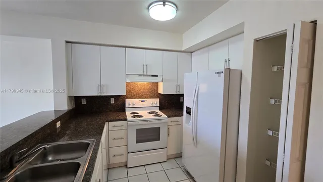 a kitchen with a refrigerator sink and stove top oven