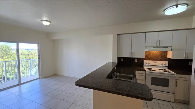 a kitchen with kitchen island a stove a sink and a granite counter top