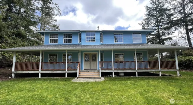 a view of a house with yard and deck