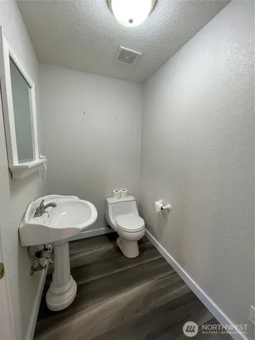 a bathroom with a sink toilet and a mirror