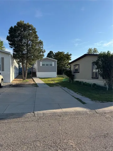a view of a house with a yard and potted plants
