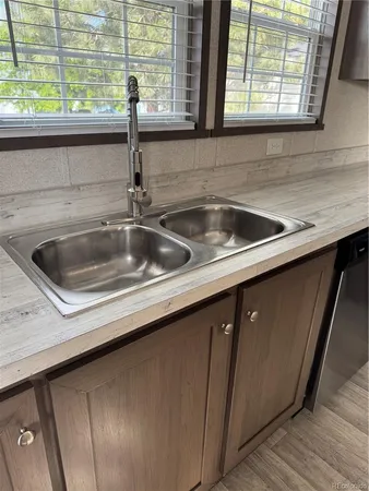 a kitchen with a sink and wooden floor