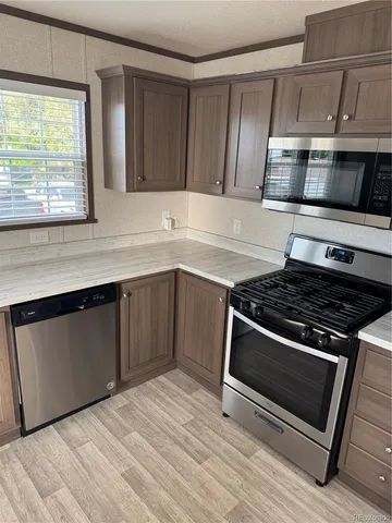 a kitchen with granite countertop a stove and a microwave