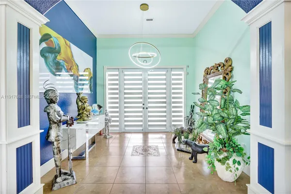 a spacious bedroom with a large bed a chandelier and windows