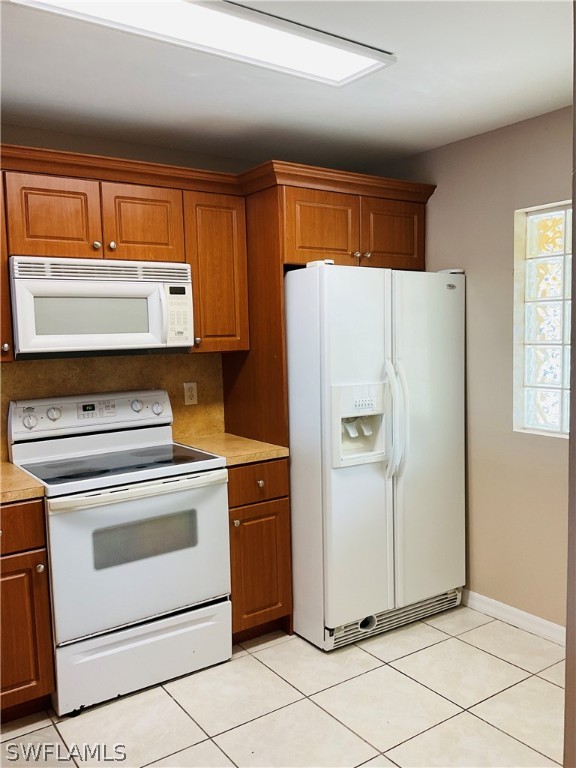 a white refrigerator freezer and a stove in a kitchen