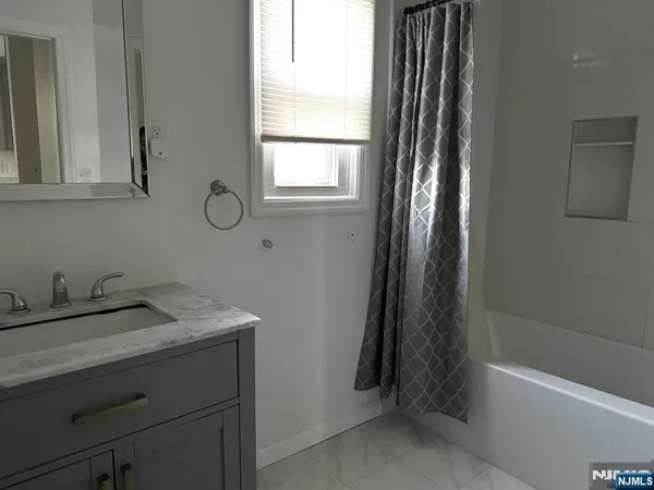 a bathroom with a granite countertop sink toilet and bathtub