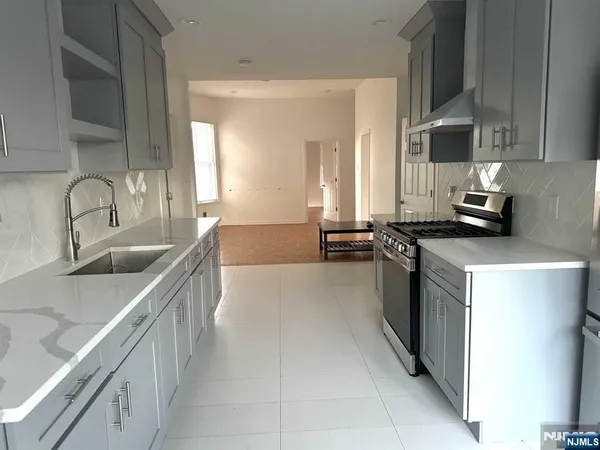 a kitchen with stainless steel appliances a sink stove and cabinets