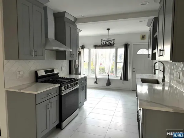 a kitchen with stainless steel appliances granite countertop a sink stove and cabinets