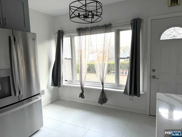 a view of a kitchen with fridge and windows