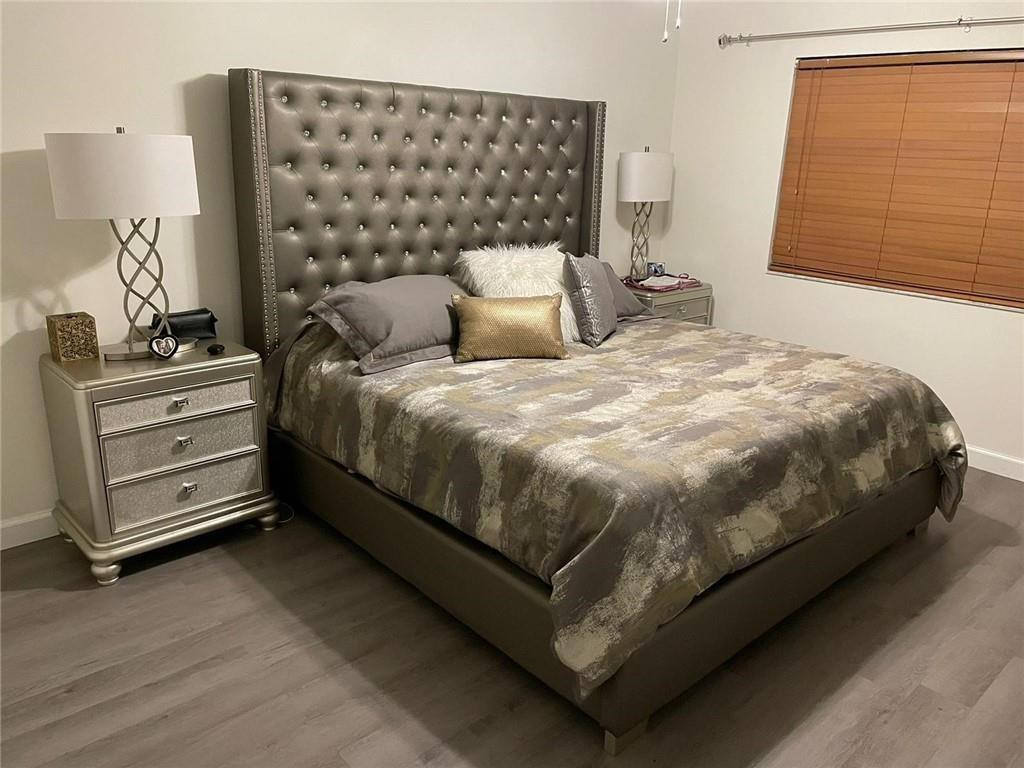 9273 Southwest 8th Street, Unit 109 Boca Raton, FL 33428 - Photo 5 of 20 a bed sitting in a bedroom next to a window with dresser