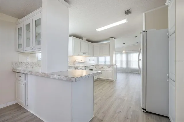 a kitchen with granite countertop white cabinets and white appliances