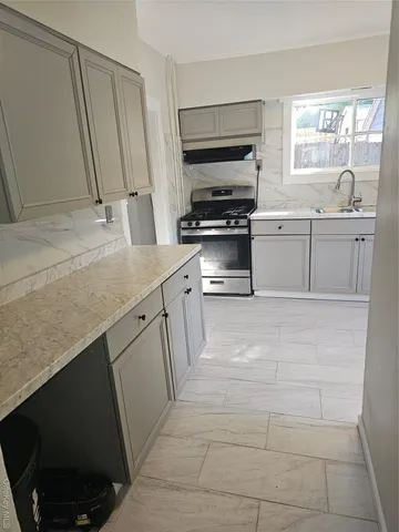 a kitchen with a sink stove and cabinets