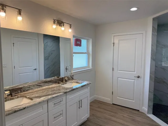 a bathroom with a granite countertop sink and a mirror