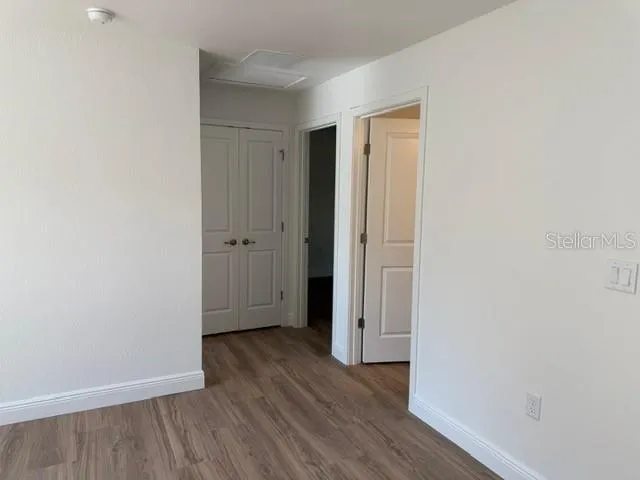 an empty room with wooden floor and closet