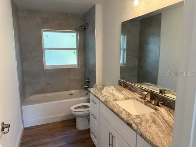 a bathroom with a granite countertop sink toilet and shower