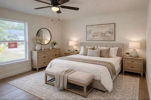 a bedroom with a bed a dresser next to a window