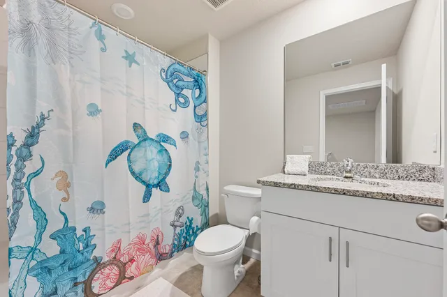 a bathroom with a granite countertop toilet and a sink