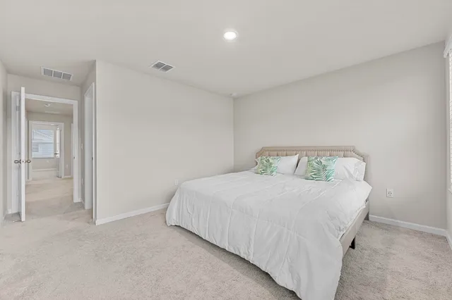 a bedroom with a bed and painting on the wall