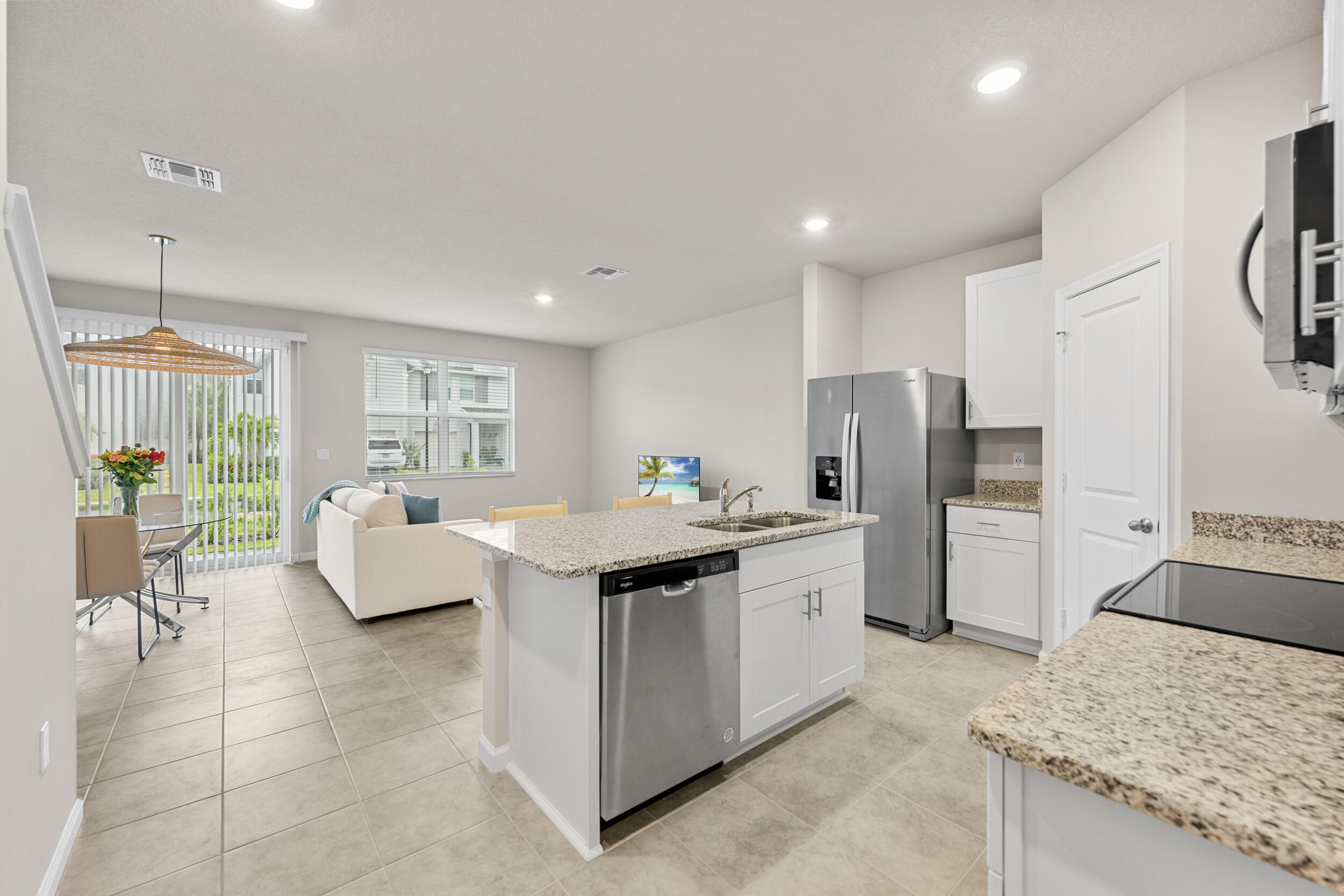 5731 Southeast Edgewater Circle Stuart, FL 34997 - Photo 4 of 42 a kitchen with stainless steel appliances granite countertop a refrigerator a sink a stove and white cabinets