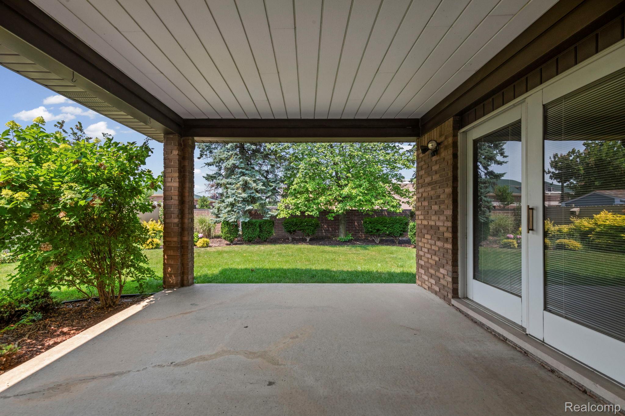 21580 Georgetown Road Trenton, MI 48183 - Photo 31 of 36 Covered patio featuring a concrete surface, brick support columns, and an exterior light fixture