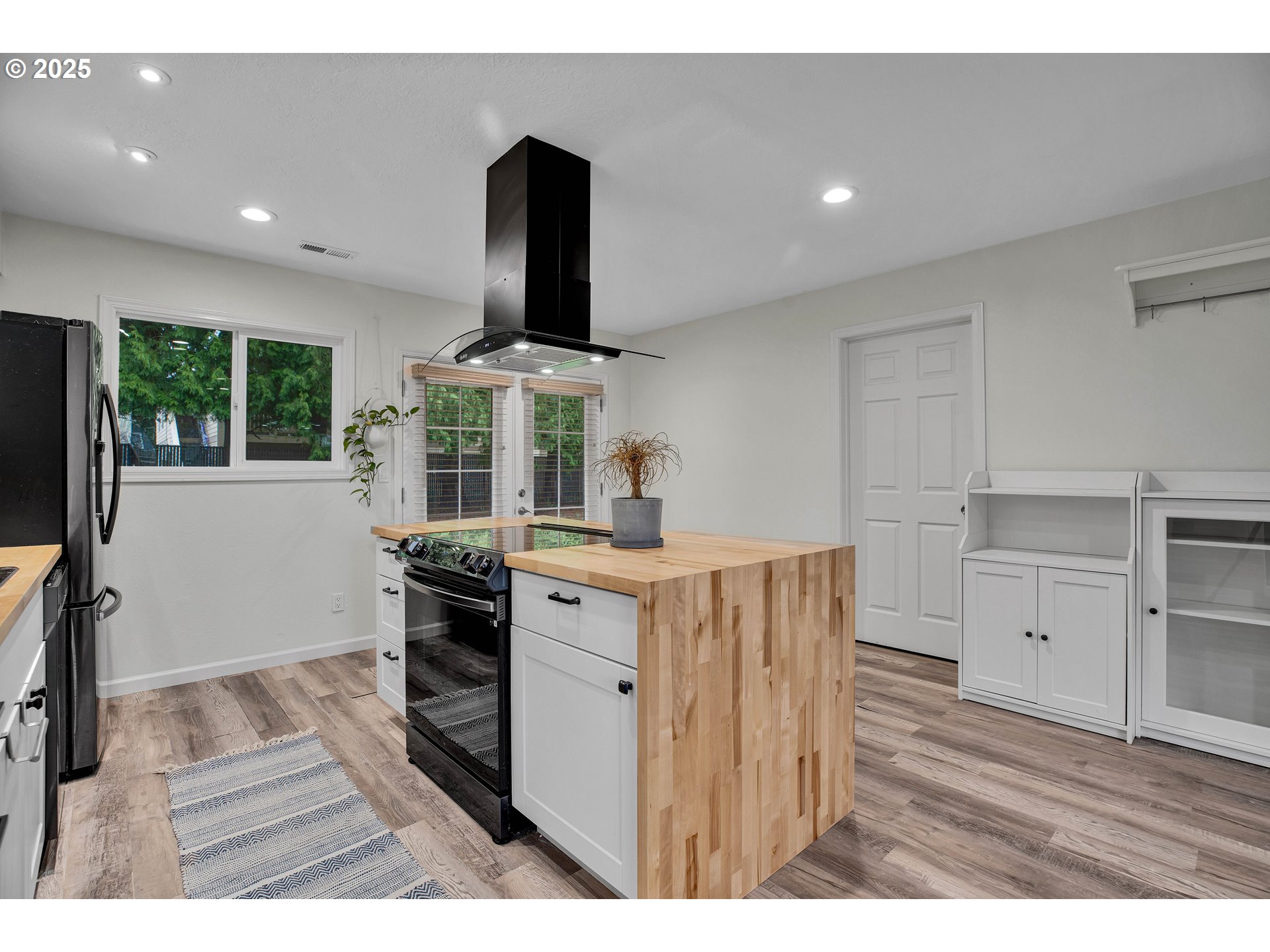 700 Southeast Hogan Road Gresham, OR 97080 - Photo 17 of 37 a kitchen with stainless steel appliances kitchen island granite countertop a stove a sink and a refrigerator with wooden floor