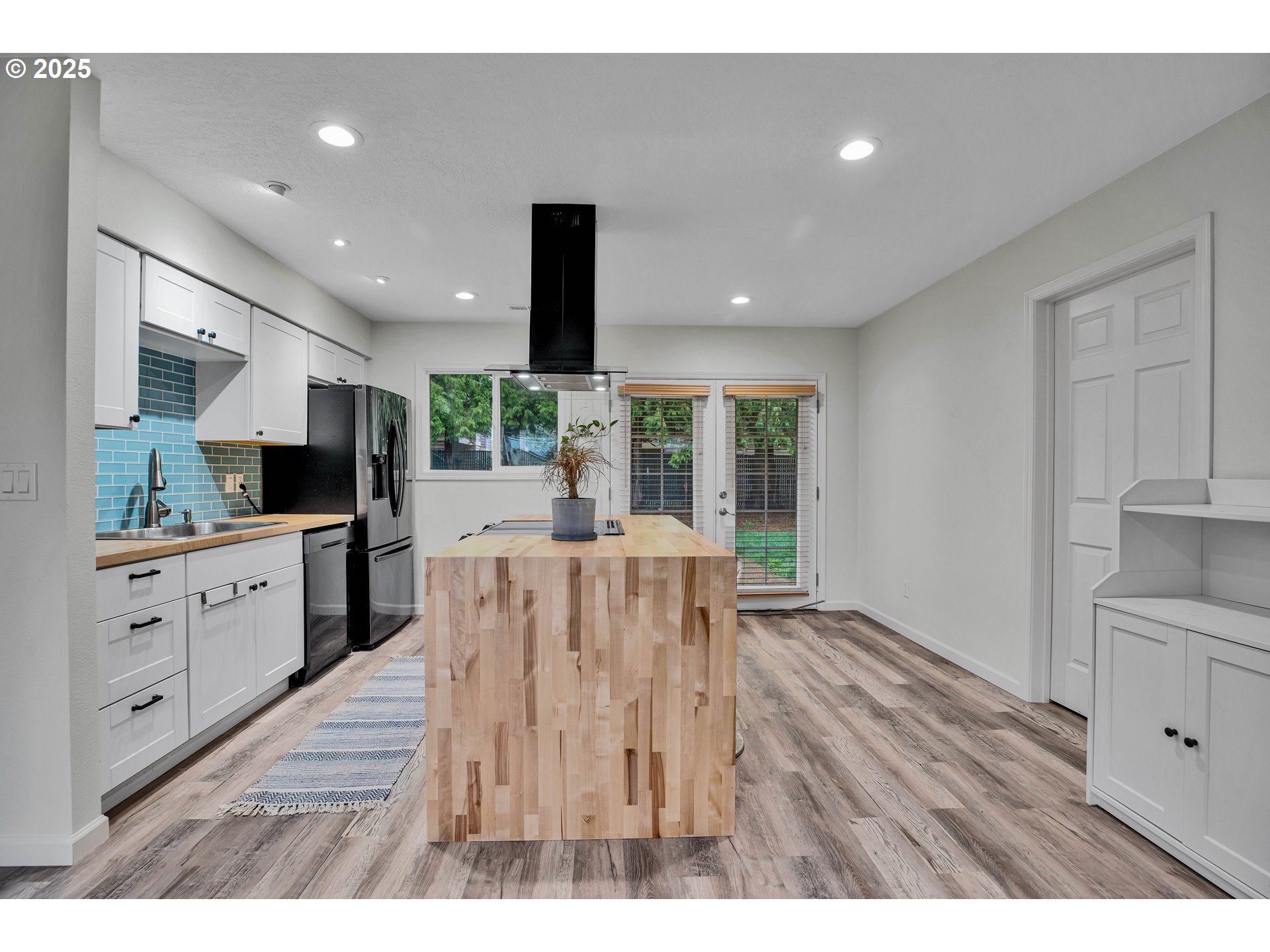 700 Southeast Hogan Road Gresham, OR 97080 - Photo 9 of 37 a open kitchen with white cabinets a sink a stove and a wooden floors