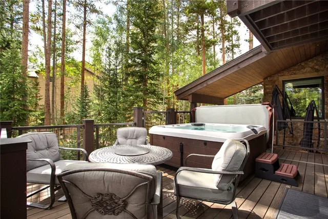 a view of a patio with table and chairs with wooden floor and fence