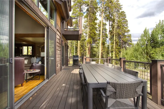 a view of a patio with table and chairs with wooden floor and fence