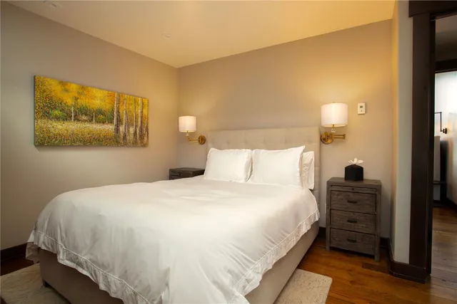 a bedroom with a bed and a painting on the wall