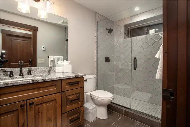 a bathroom with a granite countertop sink toilet and shower