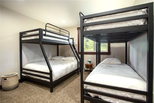 a bedroom with bunk bed and a window