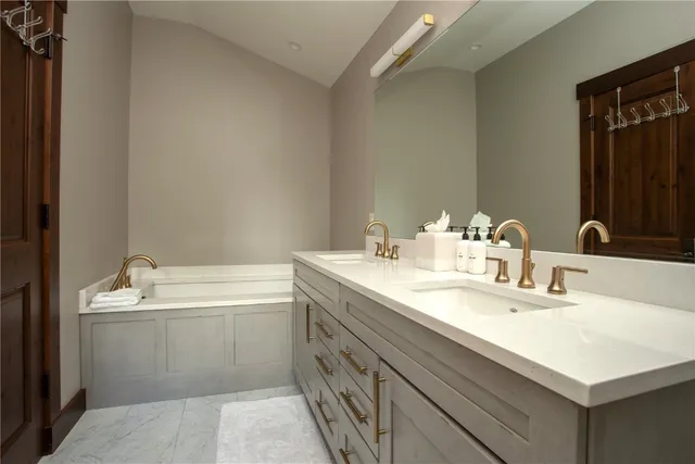 a bathroom with a sink double vanity granite and a bathtub