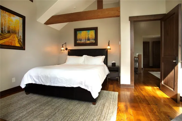 a bedroom with a bed and a painting on the wall