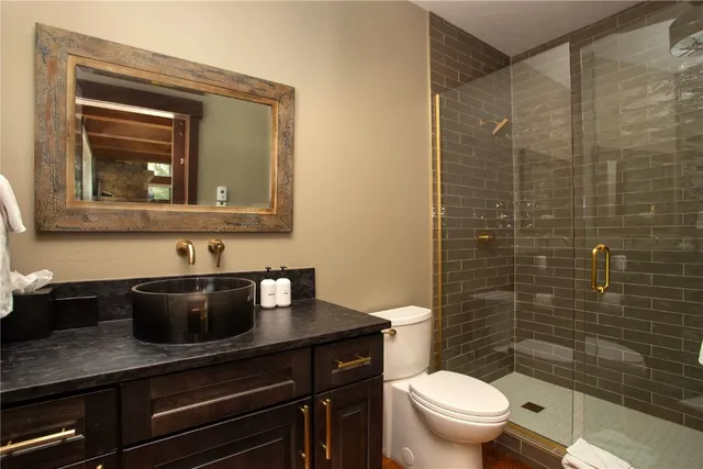 a bathroom with a granite countertop toilet sink and mirror