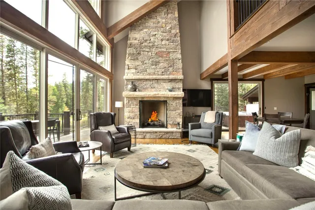 a living room with furniture a fireplace and a floor to ceiling window
