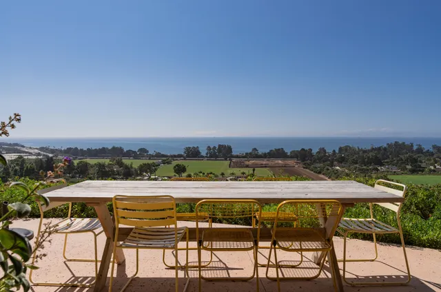 a living room with a table and a floor to ceiling window