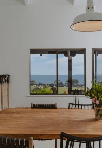 a dining room with furniture and a floor to ceiling window