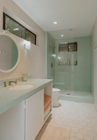 a bathroom with a sink a toilet and shower