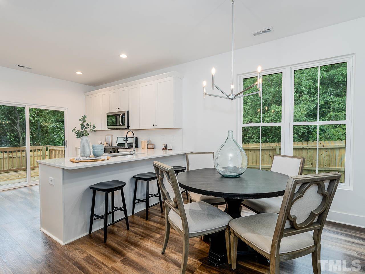 614 East Ellerbee Street Durham, NC 27704 - Photo 13 of 28 a view of a dining room with furniture wooden floor and a chandelier