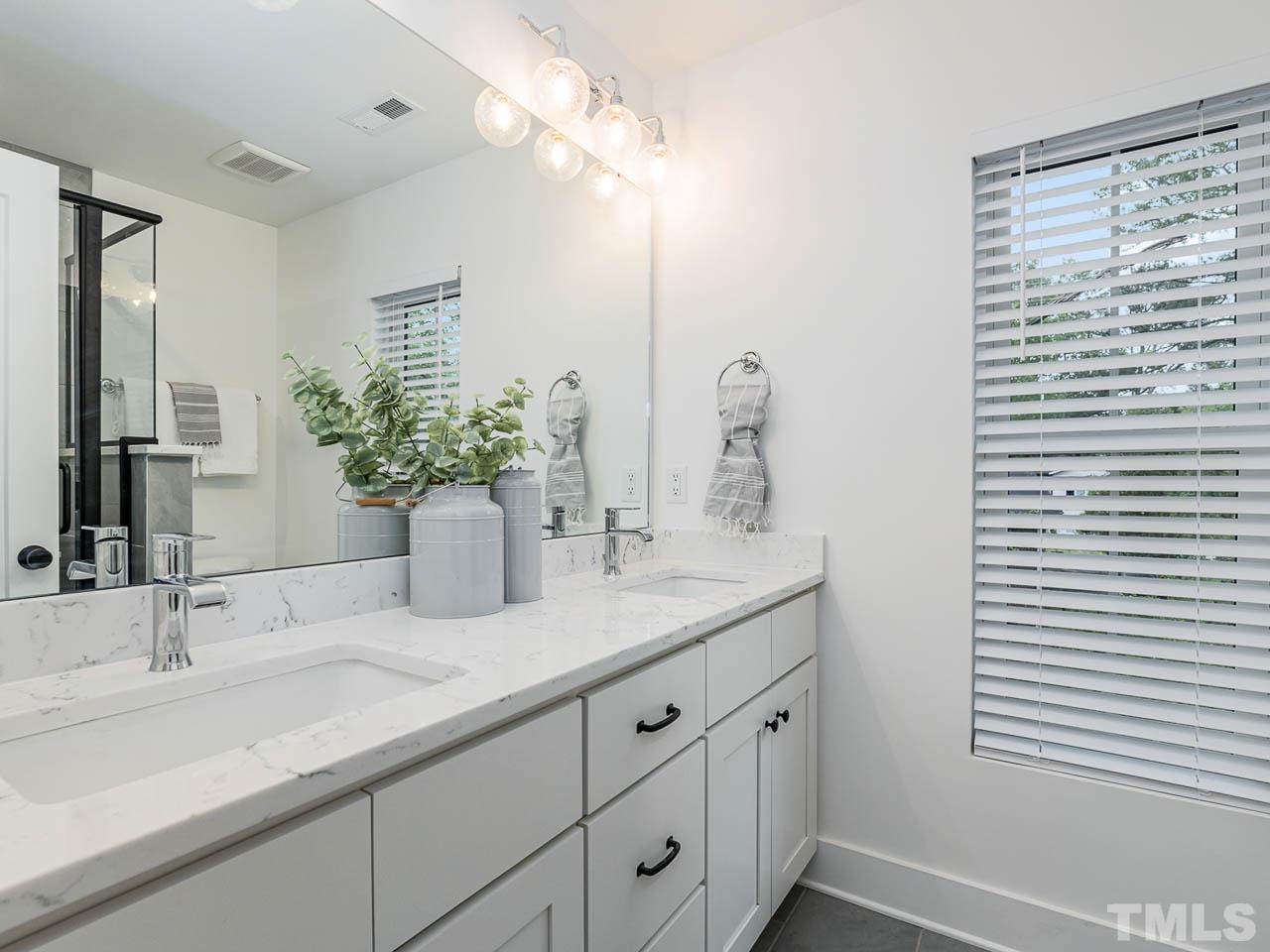 614 East Ellerbee Street Durham, NC 27704 - Photo 21 of 28 a bathroom with a double vanity sink and a mirror