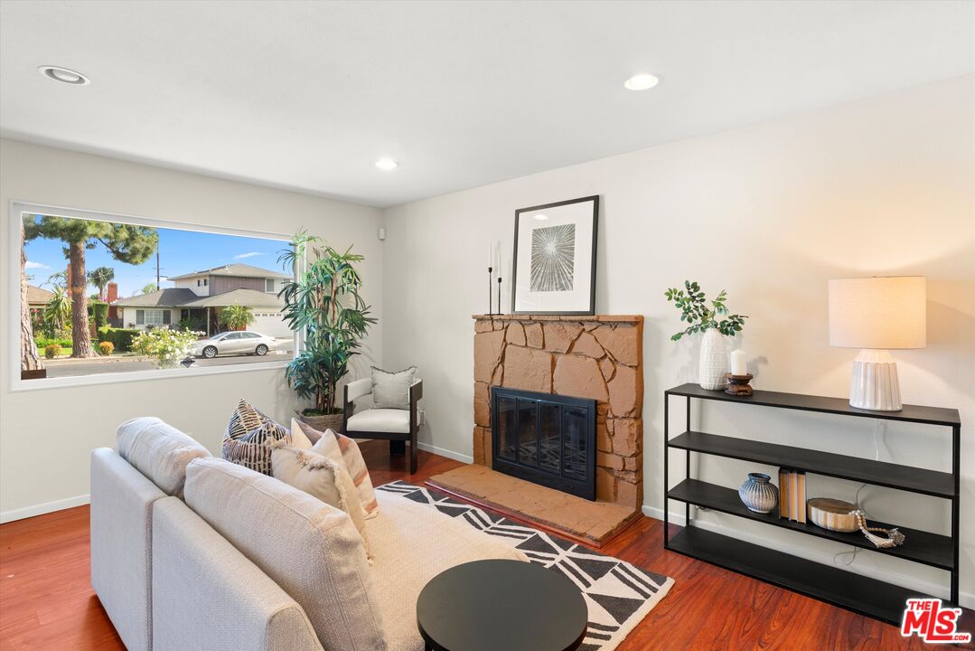 1407 East Kramer Drive Carson, CA 90746 - Photo 3 of 24 a living room with furniture a fireplace and a potted plant