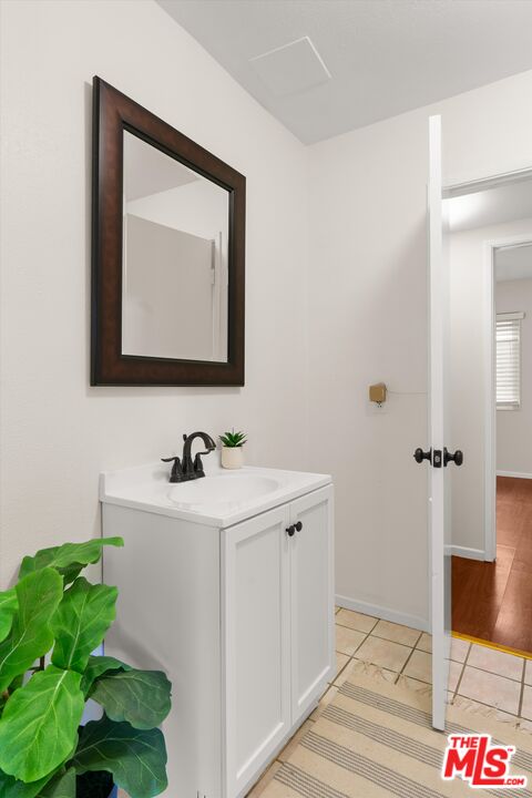 1407 East Kramer Drive Carson, CA 90746 - Photo 10 of 24 a bathroom with a sink and a mirror