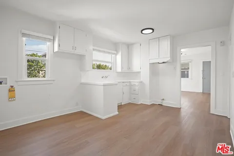 a room with a white cabinets and wooden floor