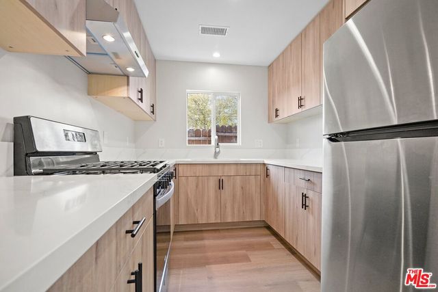 a kitchen with granite countertop a sink stove and refrigerator