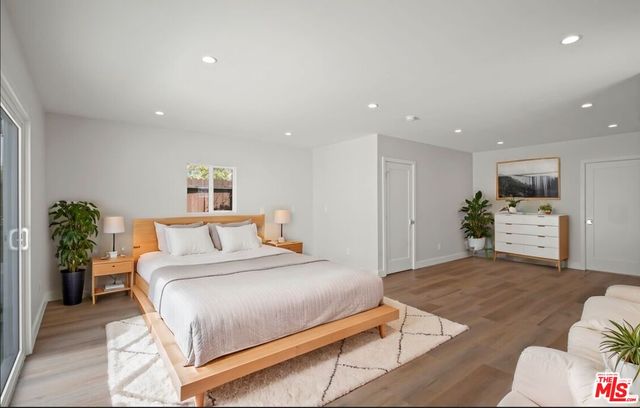 a spacious bedroom with a bed and a view of kitchen